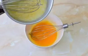 Gradually pour the mixture into a bowl with yolks. Mix everything at once so that the yolks do not overcook.