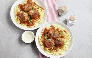 Place the pasta on the plates, and place the meatballs with the sauce on them.