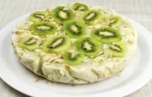 After an hour, take the cake out of the refrigerator, remove the paper. Decorate the top with kiwi slices.