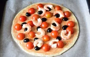 Then evenly distribute the shrimp and olives, and also cut them into two halves.