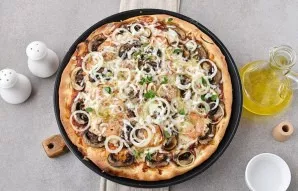 Immediately sprinkle the hot pizza with grated parmesan to enhance the taste, drizzle with olive oil and garnish with fresh basil.