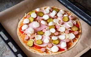 Lay out the mozzarella, also pre-cut into thin slices. Place the pizza in the oven, already preheated to 180 degrees, for 15 minutes.