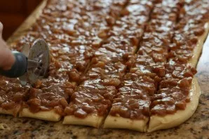Grease the surface of the dough with caramel and put the cooled apple filling. Carefully cut the dough into strips. This is convenient to...