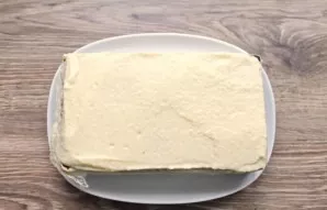 Grease the cookies again with cream. Place the third row of cookies, and spread all the remaining cream on top of the cake. Place the cak...