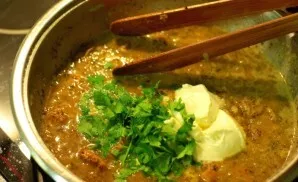 Then pour in sour cream and finely chopped herbs, mix everything thoroughly. Turn off the fire.