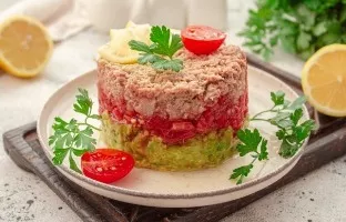 Layered salad with tuna, tomatoes and avocado